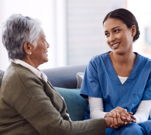 caregiver holding the senior woman's hand