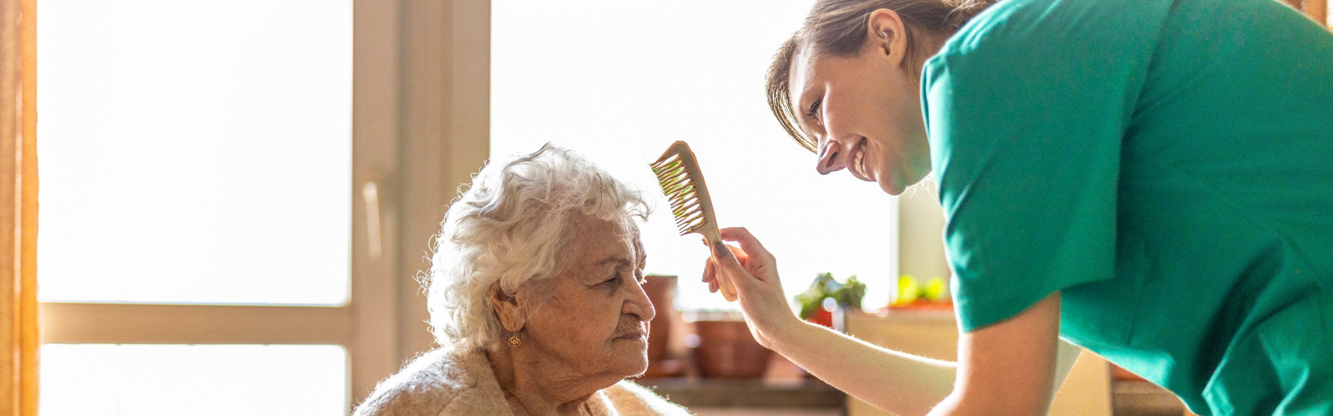 caregiver combing the senior woman's hair