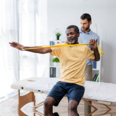 african american man sitting on massage table and training